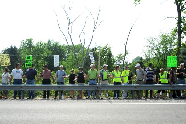 Supporters rally along a guard rail near Camp Take Notice as a means to promote awareness and raise funds for the camp during a rally along Wagner Road on Thursday.  Melanie Maxwell I AnnArbor.com